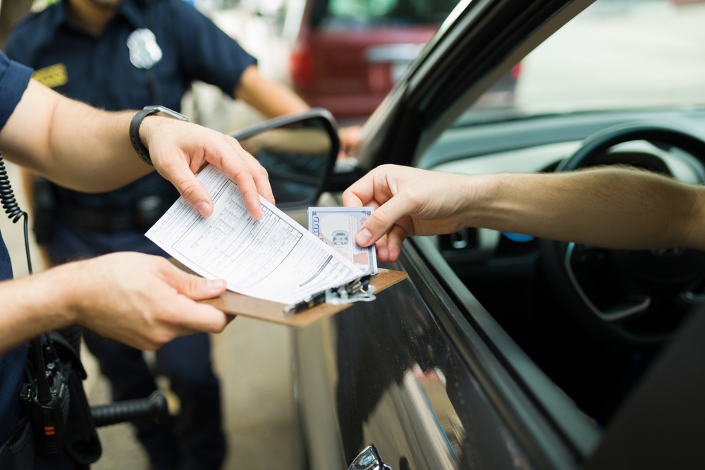 Driver giving bribe money to police cops for receiving a traffic fine or speeding ticket 